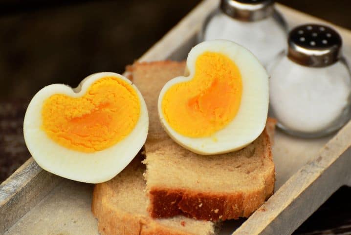 Ovos cozidos partidos na metade, sobre uma fatia de pão de forma.