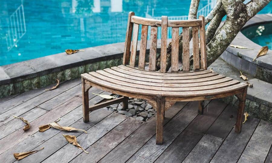 banco de madeira perto de uma piscina