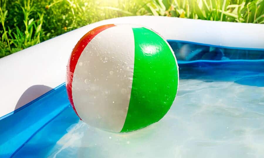 Piscina inflável com bola flutuando na água.
