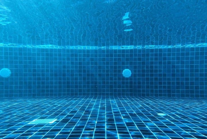 fundo da piscina com azulejos azuis.