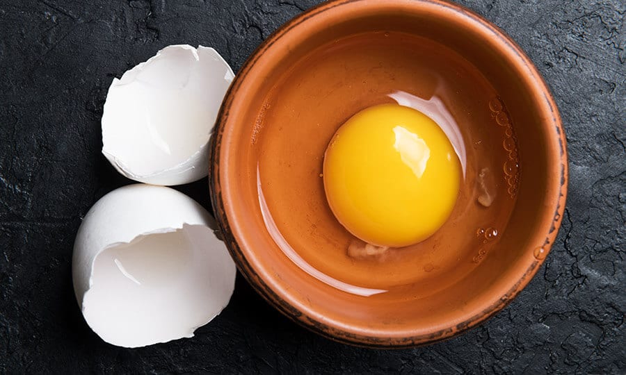 Gema de ovo dentro de um bowl de cerâmica marrom.