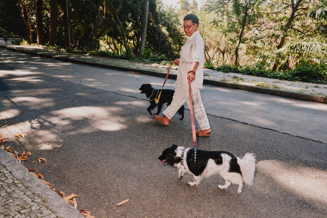 Mulher passeando com dois cachorros.