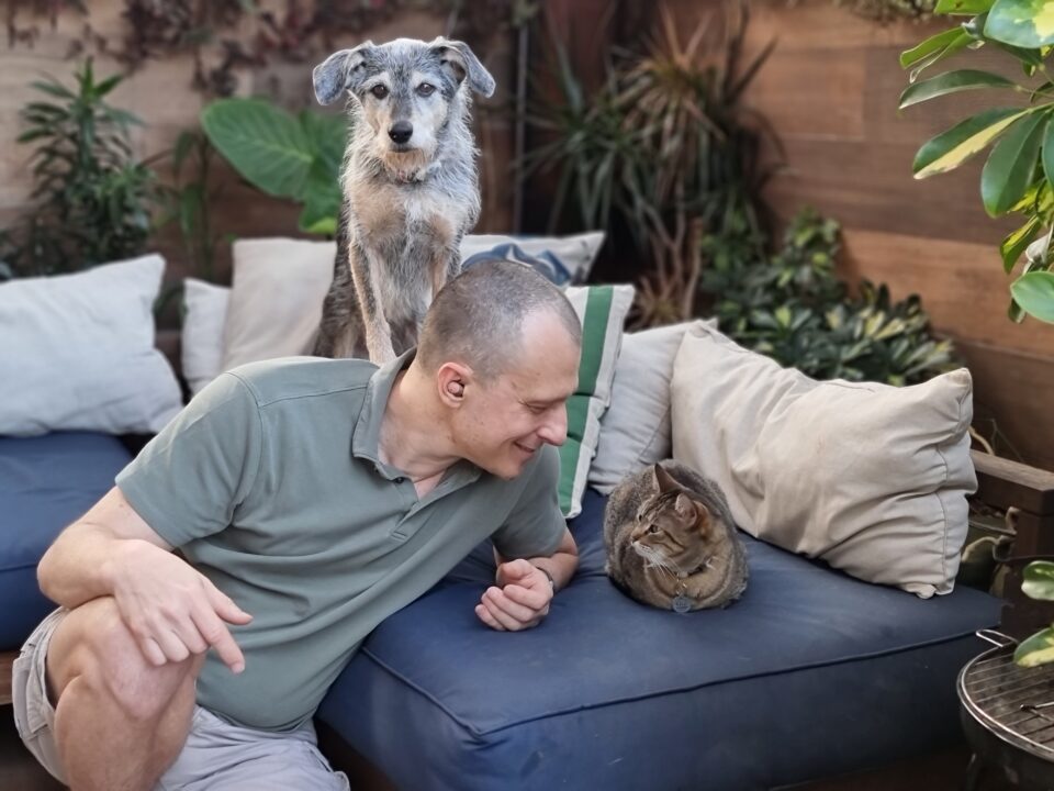 Dr. Pet com dois cachorros, próximos a um sofá.