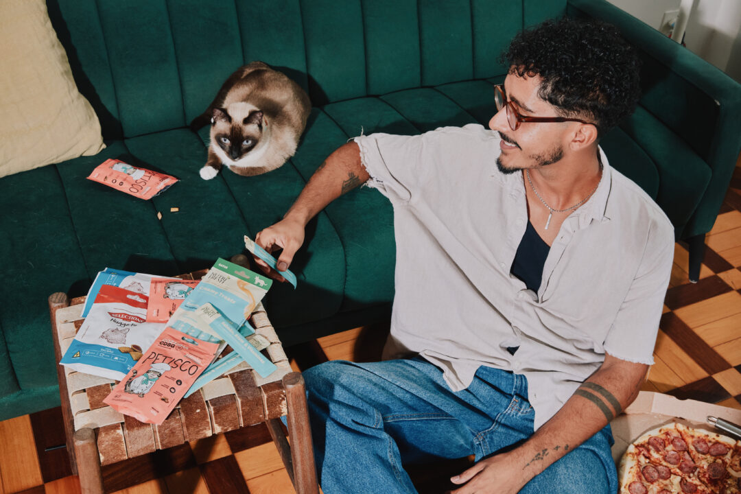 Tutor sentado ao lado do gato.